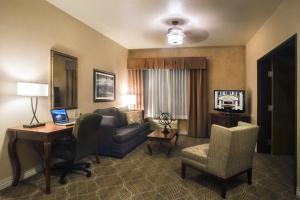a living room with a couch and a desk with a laptop at Inn on Barons Creek in Fredericksburg