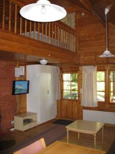 Alppimaja في لابوا: غرفة معيشة بجدران خشبية وطاولة وتلفزيون