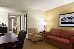 Habitación de hotel con sofá, mesa y silla en Country Inn & Suites by Radisson, Pineville, LA, en Pineville