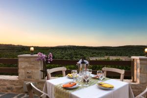 stół z kieliszkami do wina na balkonie z widokiem w obiekcie Kampos Villas, pure elegance, By ThinkVilla w mieście Achlades