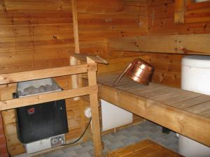 eine Holzhütte mit Ofen und Toilette in der Unterkunft Alppimaja in Lapua