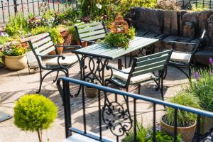een patio met een tafel en stoelen en een bank bij The Grafton Guest House in Llandudno