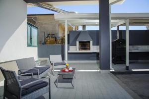 sala de estar con sillas y patio con chimenea en B&B Villa Fiorita, en Piazza Armerina