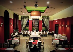 a restaurant with white tables and chairs and red walls at Dolnośląski in Ząbkowice Śląskie