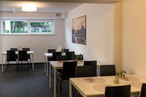 a waiting room with tables and chairs and a window at City Rooms Szczecin in Szczecin
