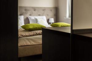 a bedroom with a bed with green pillows on it at City Rooms Szczecin in Szczecin +45 photos