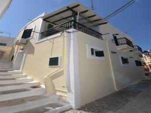 a white building with stairs and a balcony at Akadia Syros in Ermoupoli