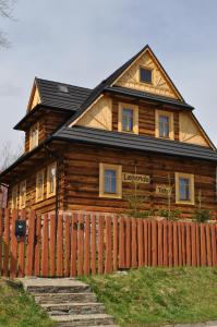 una casa de madera con una valla delante en Legenda Tatr, en Zakopane