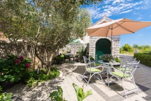 a patio with a table and chairs and an umbrella at Apartment Lorenzo in Trogir