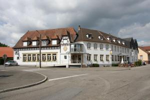 ein großes weißes Gebäude mit braunem Dach auf einer Straße in der Unterkunft Hôtel Restaurant À L'Etoile in Merkwiller-Pechelbronn