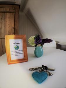 einen Tisch mit einem Bild und einem Paar Schlüssel in der Unterkunft B&B Little Miss Sunshine in Zandvoort