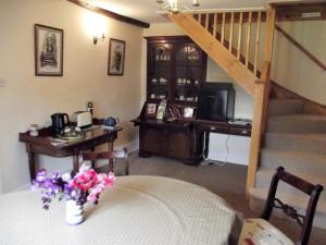 a living room with a table with a vase of flowers at Deepaller Farm B&B in Tiverton