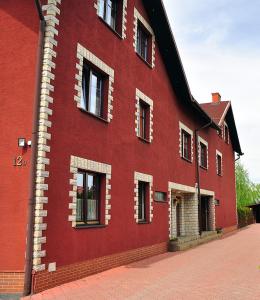 a red building with windows on the side of it at Villa Beata in Nowy Sącz