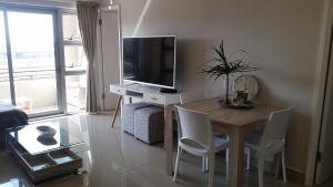 a living room with a table and a tv and a table and chairs at Ashton Apartments Central Park in Durban