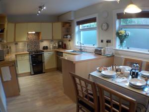 a large kitchen with a table and chairs in it at 16 Admiralty in Arrochar