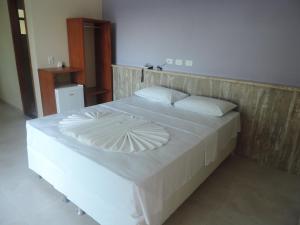 a large white bed with a wooden head board at Areia do Atlantico Hotel in Porto Seguro