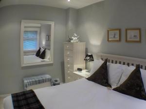 a bedroom with a bed and a dresser and a mirror at 16 Admiralty in Arrochar