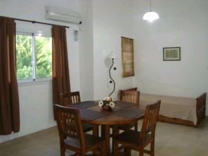 a dining room with a table and chairs and a bed at Brisa Serrana in Potrero de los Funes