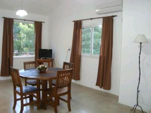 a dining room with a table and chairs and two windows at Brisa Serrana in Potrero de los Funes