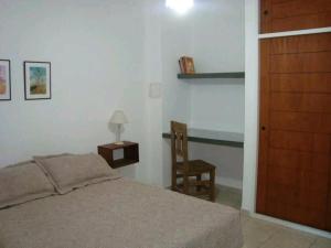 a bedroom with a bed and a table and a chair at Brisa Serrana in Potrero de los Funes