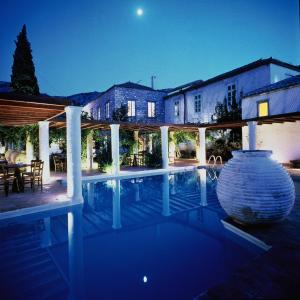 une villa avec une piscine la nuit dans l'établissement Bratsera Boutique Hotel, à Hydra