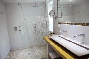 a white bathroom with a shower and a sink at Le Pont de L'Ouysse in Lacave
