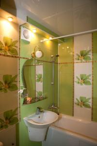 uma casa de banho com um lavatório, um chuveiro e uma banheira em Lovely Studio in the Heart of the City em Vinnytsya
