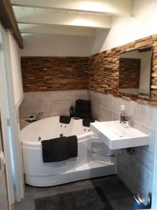 a bathroom with a tub and a sink at De Kasteelboerderij in Ruurlo