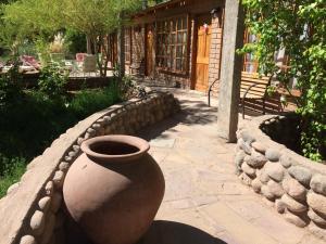 a large vase sitting on a stone fence at Hotel Corvatsch Chile in San Pedro de Atacama