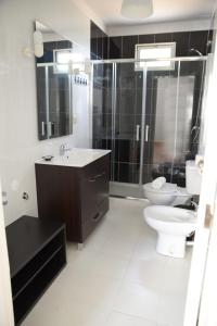 a bathroom with a sink, toilet and shower at Porto Smart Apartments- airport in Perafita