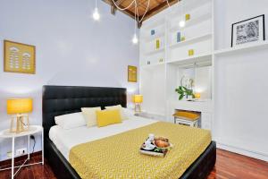 - une chambre avec un grand lit et une couverture jaune dans l'établissement Laterano 238 Apartment, à Rome