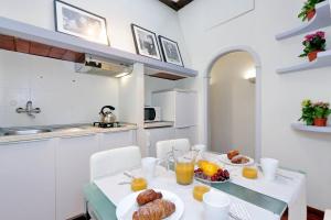 ローマにあるLaterano 238 Apartmentのキッチン(食べ物とオレンジジュースを用意したテーブル付)