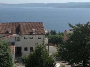 a view of a house with the ocean in the background at Odvojak Apartments in Crikvenica