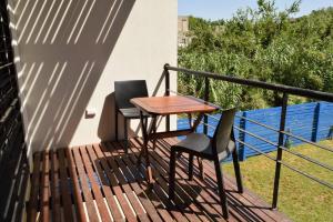 two chairs and a wooden table on a balcony at Departamentos Esperanza in Colón