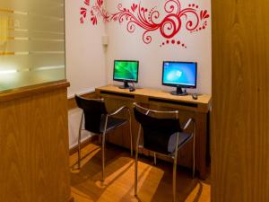 
a desk with a laptop computer and a monitor on it at Hotel España in Mar del Plata
