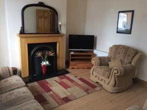 a living room with two chairs and a fireplace at Greencastle in Kilkeel