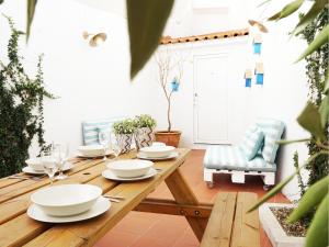 a wooden table with white dishes on top of it at Combro by Patio 25 in Lisbon