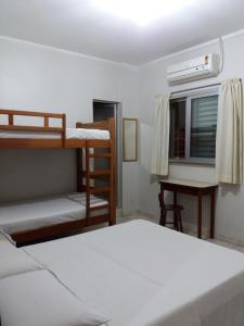 Apeninos Suites Basicas في ساو باولو: غرفة نوم مع سريرين بطابقين ومكتب