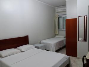 um quarto com 2 camas e um espelho em Apeninos Suites Basicas em São Paulo