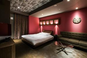 1 dormitorio con cama, sofá y TV en Hotel Rio (Adult Only), en Sapporo