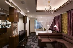 una camera d'albergo con divano e letto di Hotel Rio (Adult Only) a Sapporo