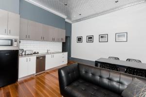 a kitchen with a black leather couch in a room at Bespoke On Main in Rutherglen