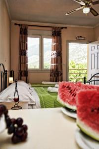 - une chambre avec un lit et une table avec des tranches de pastèque dans l'établissement Anestis Studios, à Lidia