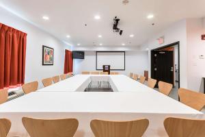 una sala de conferencias con una gran mesa blanca y sillas en Motel 6-Moosomin, SK en Moosomin