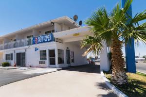 a building with a palm tree in front of it at Motel 6-Barstow, CA - Route 66 in Barstow