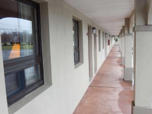 an empty hallway of a building with a window at Scottish Inns and Suites- Bordentown, NJ in Bordentown