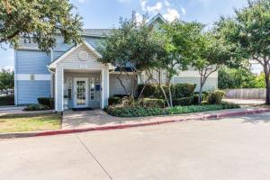 una casa con una entrada y árboles delante de ella en Studio 6-Dallas, TX - Northwest en Dallas