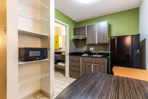 a kitchen with a black refrigerator and a microwave at Studio 6-Dallas, TX - Northwest in Dallas