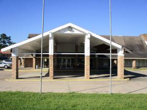 a building with a parking lot in front of it at Studio 6-Huntsville, TX in Huntsville