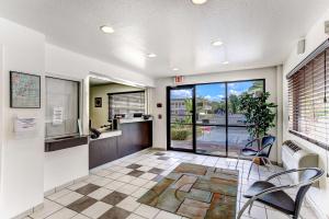 a lobby with a waiting area with chairs and a glass door at Studio 6 Extended Stay - Kissimmee, FL - Orlando in Orlando